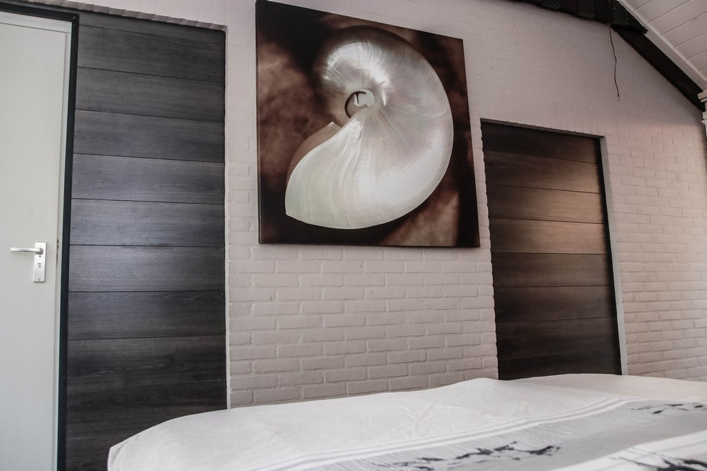 voeteinde bed met schilderij van een schelp