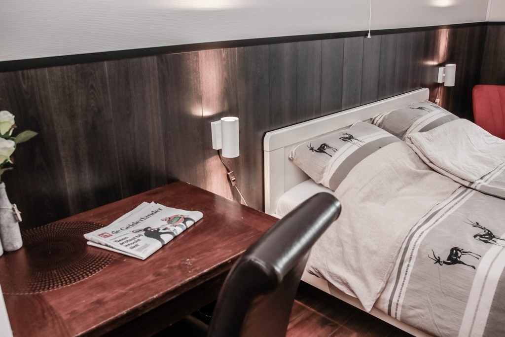 Bed met schrijftafel met donkere stoel