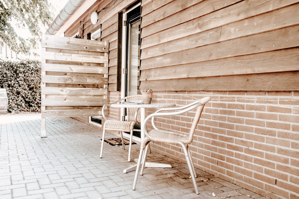 Zitje met twee stoelen en tafel buiten, met afscheiding
